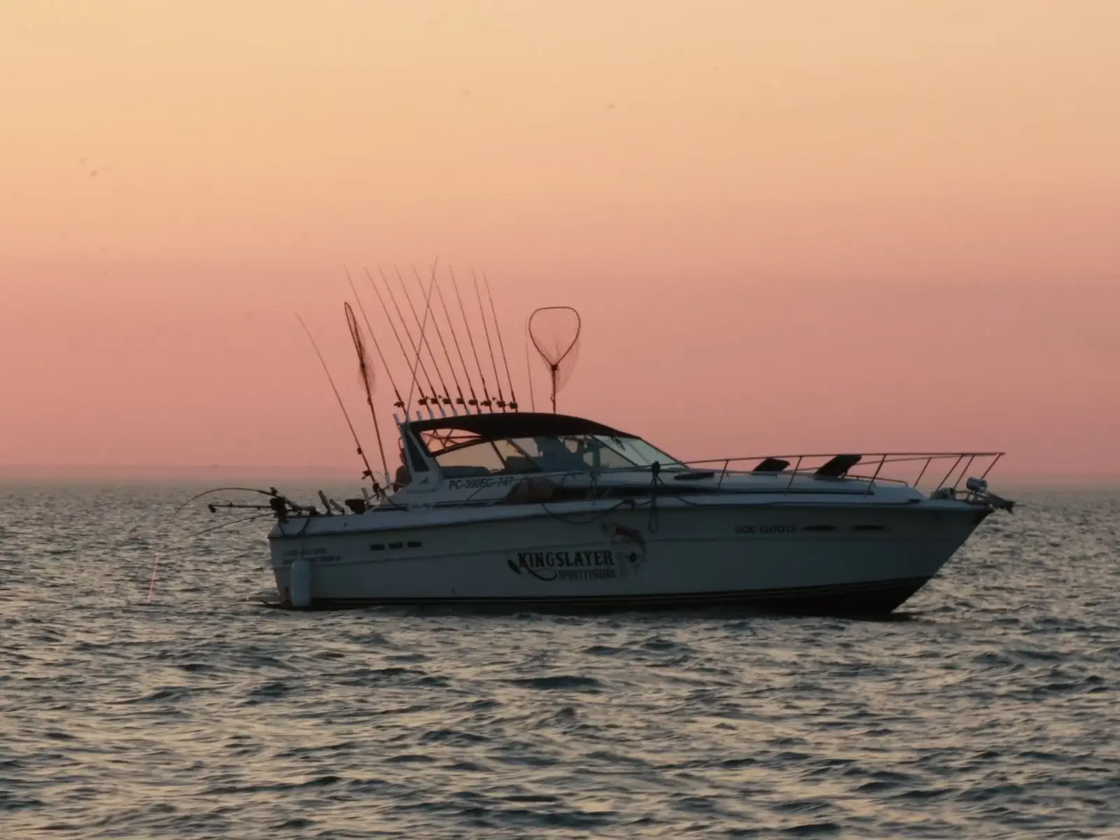 A King Slayer Sea-Ray on Lake Ontario at sunset, rods set in the riggers